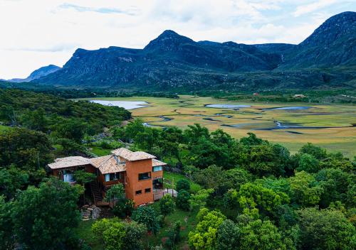 a house on a hill with mountains in the background at Sitio Jatoba/Lapinha da Serra in Santana do Riacho