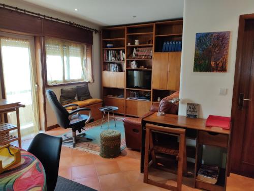 a living room with a desk and a chair at Yellow House in Senhora da Hora