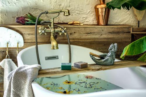 a bath tub with a faucet and a sink at Pod mazurskim niebem dom rustykalny in Piecki