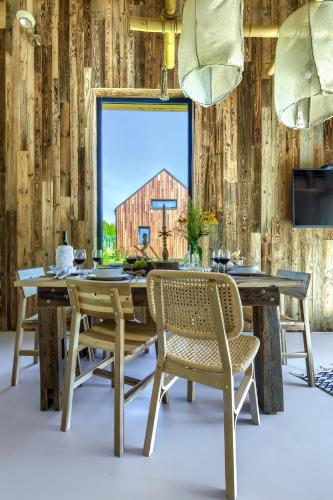 a dining room with a wooden table and chairs at Pod mazurskim niebem dom rustykalny in Piecki