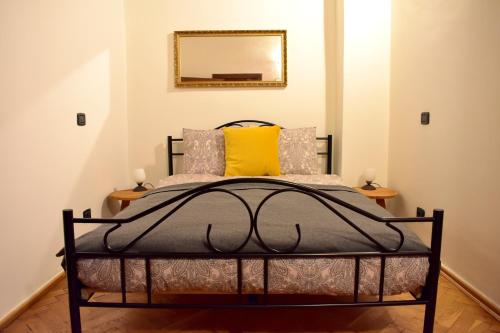 1 dormitorio con cama negra y almohada amarilla en Apartment Lesser town!, en Praga