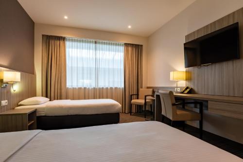
a hotel room with a large bed and a large window at Mezzo Hotel & Business in Beringen
