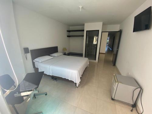 1 dormitorio con cama, escritorio y silla en Hotel Torres del Llano, en Yopal