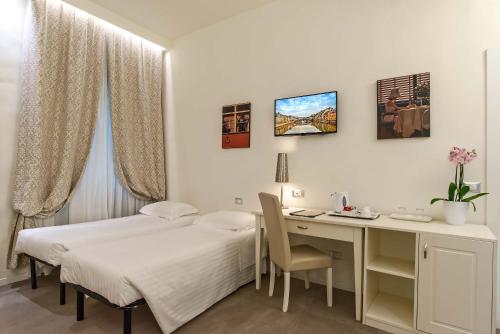 a hotel room with two beds and a desk and a desk at Hotel Accademia in Florence