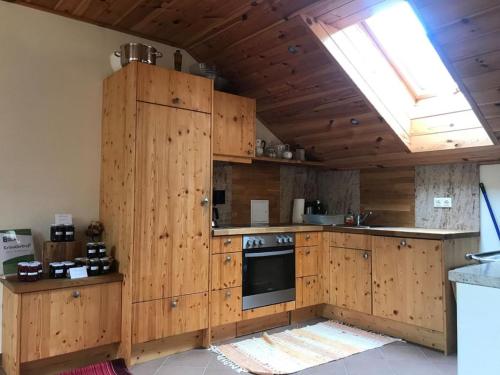 a large kitchen with wooden cabinets and an oven at Ferienwohnung 1000 Krauthof in Laimbach am Ostrong