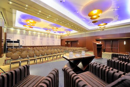 a conference room with chairs and a podium and a stage at Regent Warsaw Hotel in Warsaw