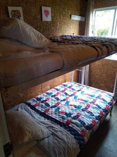 a couple of bunk beds with a quilt on them at Espectacular cabaña campestre con granja in Zipaquirá