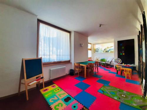 uma sala de estar com um tapete colorido no chão em HG Hotel Italia em Brusson