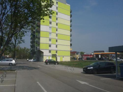 a parking lot with cars parked in front of a building at Modern and cozy apartment in Vrakuňa