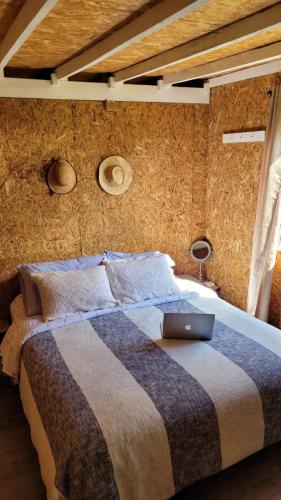 a bedroom with a bed with a laptop on it at Espectacular cabaña campestre con granja in Zipaquirá