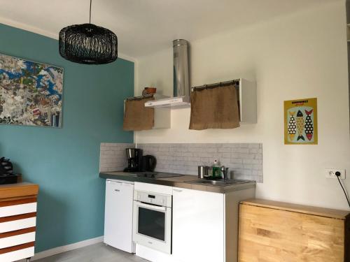 W kuchni znajduje się biała kuchenka i kuchenka mikrofalowa. w obiekcie Le Studio Sausset w mieście Sausset-les-Pins