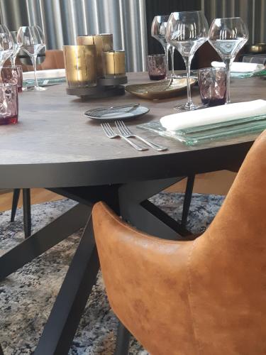 a dining room table with glasses and a chair at RAVeL Hotel Cyrano in Waimes
