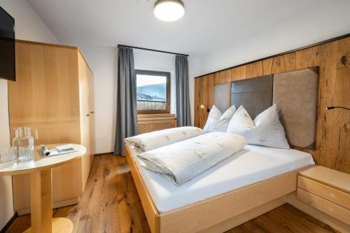 a bedroom with a large white bed with a wooden headboard at Wohn-Leben Altenmarkt Apartments in Altenmarkt im Pongau