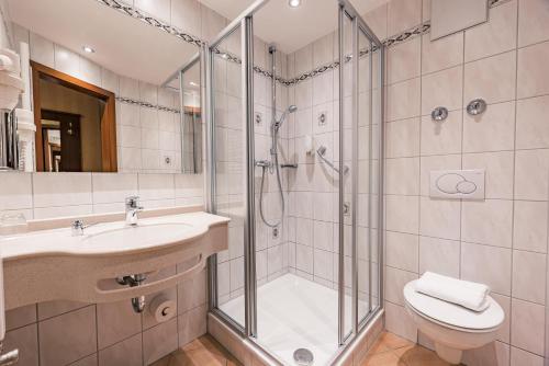 a bathroom with a shower and a sink and a toilet at Hotel Wartburg in Stuttgart