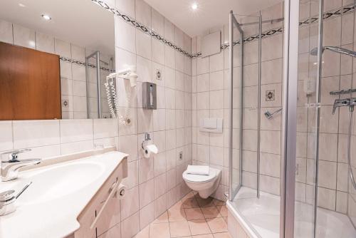 a bathroom with a sink toilet and a shower at Hotel Wartburg in Stuttgart