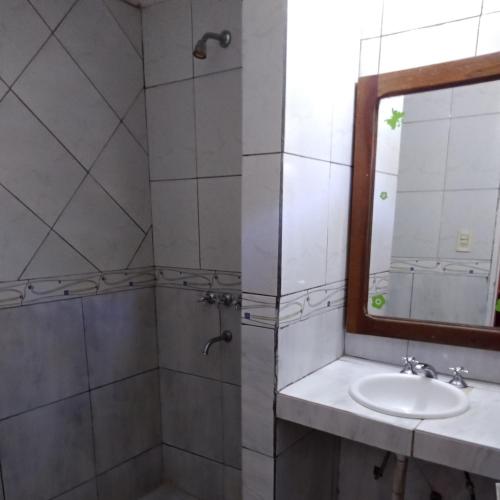 a bathroom with a sink and a mirror at Sweet Guest House in Puerto Iguazú