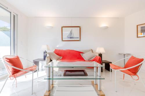 un salon avec un canapé rouge et deux chaises dans l'établissement Luxurious 2-room Apartment in Palm Beach, à Cannes