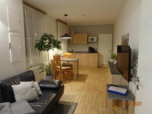 a living room with a couch and a table and a kitchen at Ferienwohnungen Pilke in Oranienburg