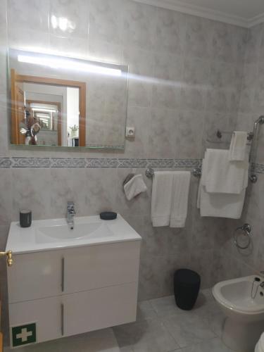 a bathroom with a sink and a toilet and a mirror at Studio Apartment Ocean View in Portimão