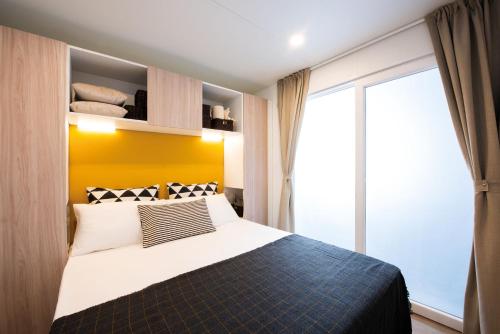 a bedroom with a bed and a large window at Club del Sole Jesolo Family Resort in Lido di Jesolo