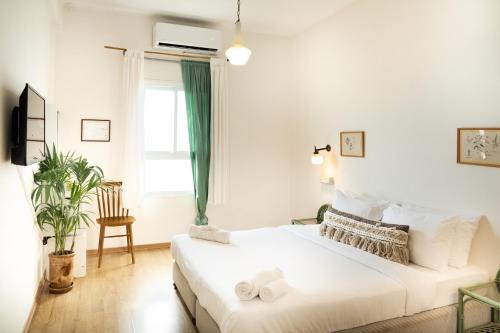 a white bedroom with a bed and a window at Beit Oren Hotel in Beit Oren