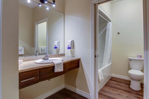 a bathroom with a sink and a toilet at Motel Roberval in Roberval