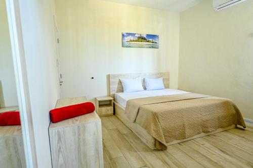 a small bedroom with a bed and a red chair at New Villa Geranium in Grand Baie