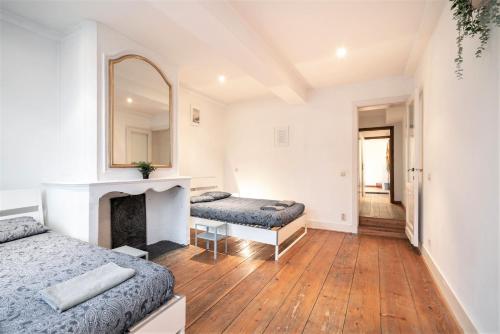 a bedroom with two beds and a mirror at The Capital Street Lodge in Antwerp