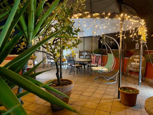 a patio with a table and some plants and lights at Miglioranzi Rooms in Verona