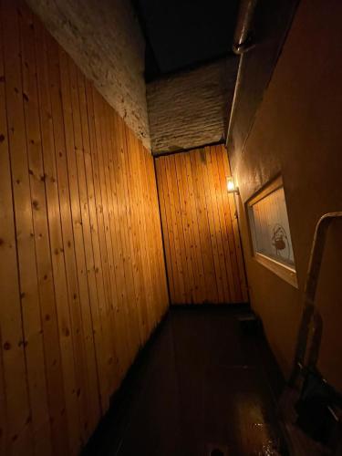 a dark room with a wooden wall and a light at Room of Tournai in Tournai