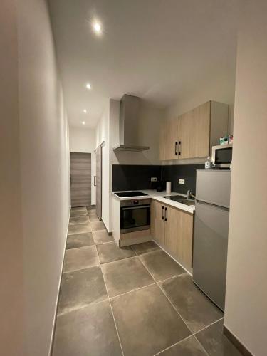 a kitchen with white appliances and a tile floor at Room of Tournai in Tournai