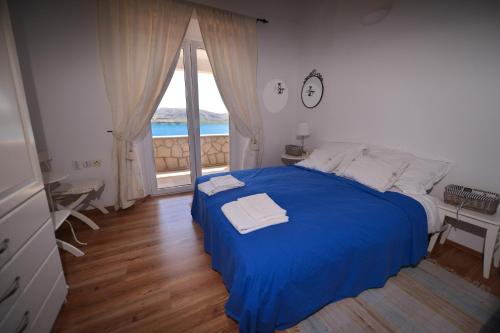 a bedroom with a blue bed and a large window at Holiday Home Fiola in Zubovići