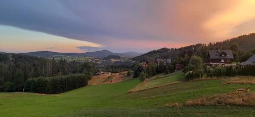 a rainbow in the sky over a green field at Apartament & Spa Rosa in Istebna