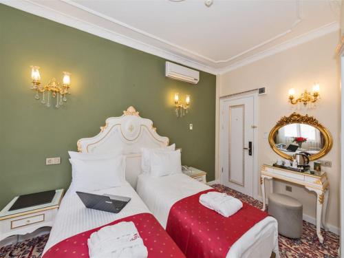 a bedroom with two beds and a mirror at Galatower Hotel in Istanbul