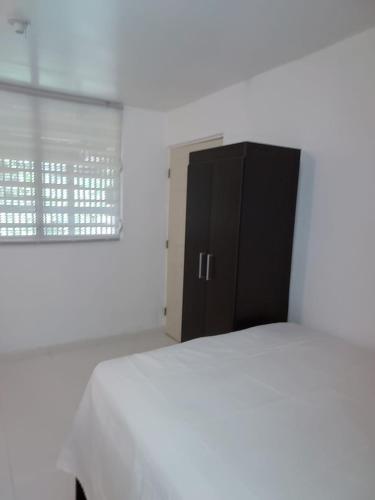 ein Schlafzimmer mit einem Bett und einem schwarzen Schrank in der Unterkunft Confort y Relajacion apto 5 in Dorado