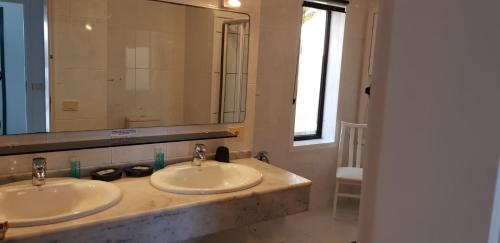 a bathroom with two sinks and a large mirror at Villa Los Ojos in Charco del Palo