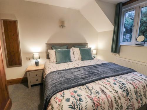 a bedroom with a large bed and a window at Ramblers Cottage in Whitby