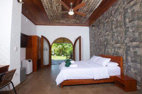 1 dormitorio con cama y pared de piedra en Lodge Casa de Campo "APU SAMAY", en Tarapoto