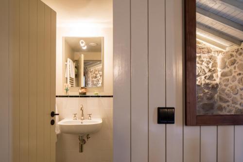 a bathroom with a sink and a mirror at Traços D'Outrora in Vale de Cambra