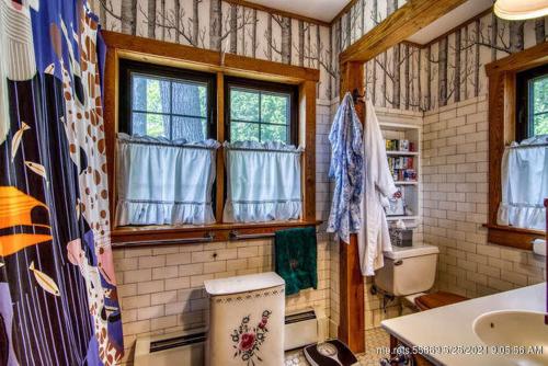 een badkamer met een wastafel, een toilet en ramen bij Whispering Pines in Orland