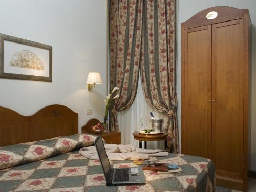 a hotel room with a laptop on a bed at Hotel Aberdeen in Rome