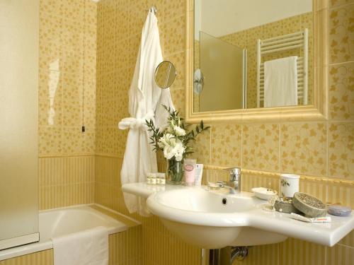 a bathroom with a sink and a mirror and a tub at Hotel Aberdeen in Rome