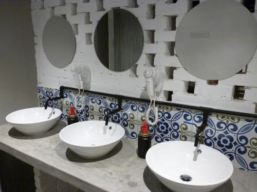 a bathroom with two sinks and two mirrors at Ola Hostel in Melaka