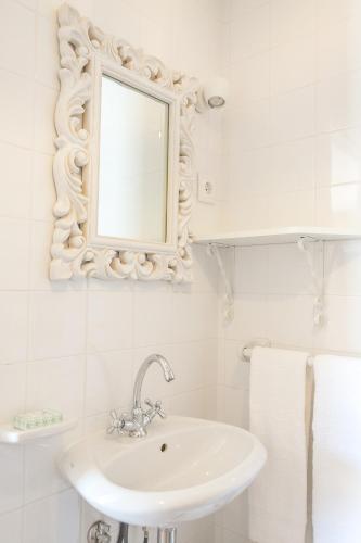a white bathroom with a sink and a mirror at Casa Monte do Cervo in Vila Nova de Cerveira