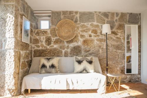 a bedroom with a stone wall with a bed at Casa Monte do Cervo in Vila Nova de Cerveira