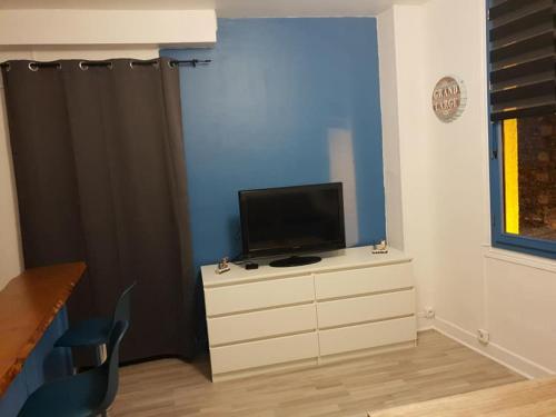 a room with a dresser with a television on it at studio jonquille in Le Tréport