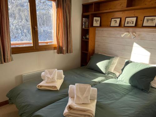 a bedroom with two beds with towels on them at Le CAPRICORNE OLYMPIE 3 in Les Allues