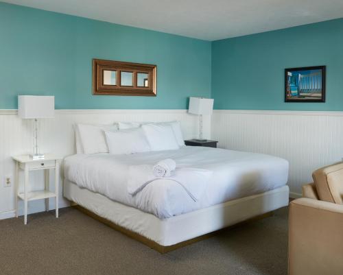 a bedroom with a white bed and a blue wall at Breezeway Boutique Hotel in Westerly