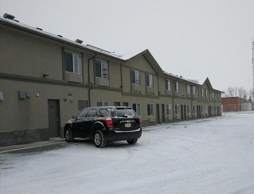 een zwarte auto geparkeerd voor een gebouw bij Westlake Inn in Strathmore