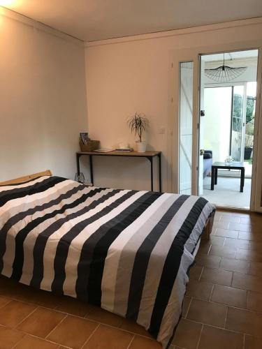 - une chambre avec un lit et une couette en noir et blanc rayée dans l'établissement Appartement Rez de villa - Porte des Calanques, à La Redonne